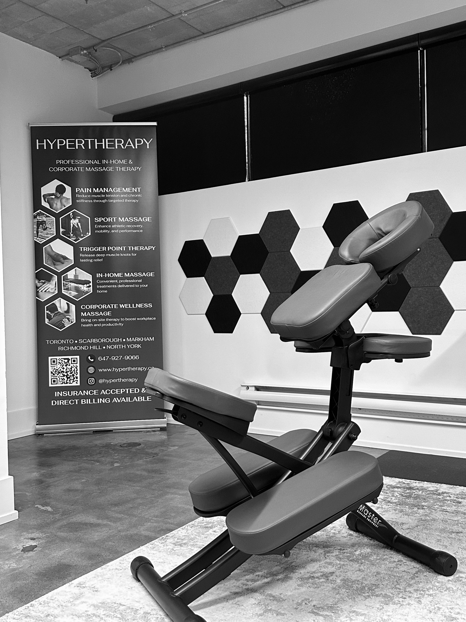 A HyperTherapy ergonomic massage chair beside the branded banner at a corporate event
